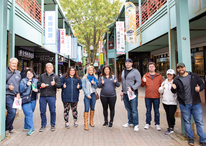 Tourist group smiling and giving thumbs up in Chicago's Chinatown