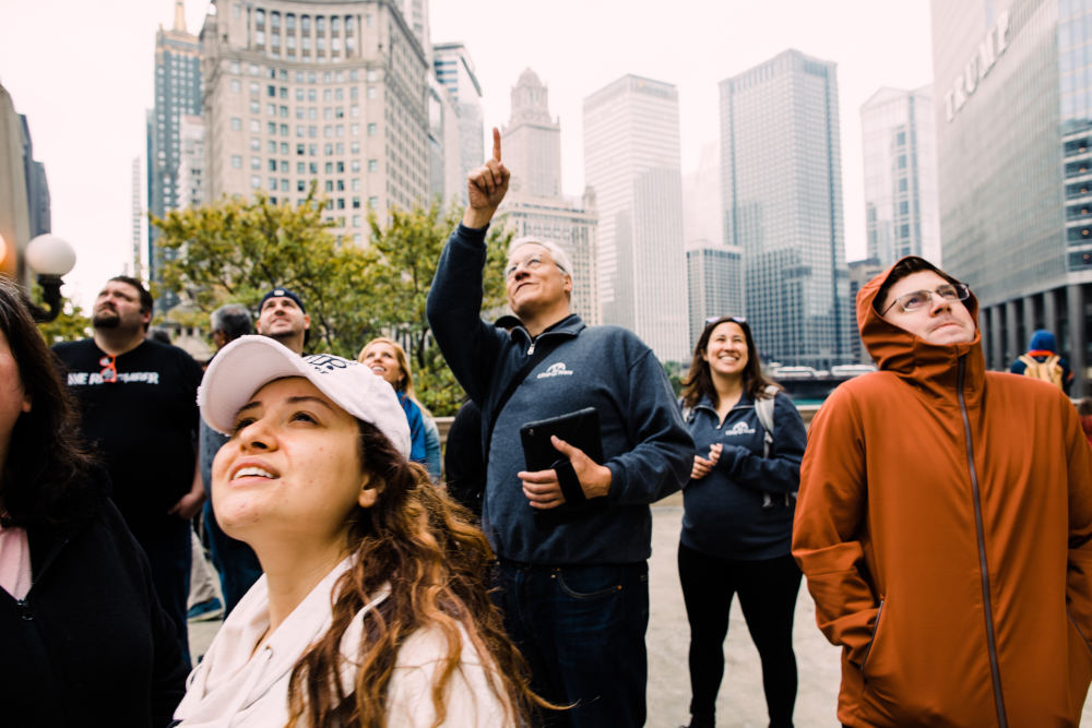 Tourists in Chicago on a tour looking up at Skyscrapers